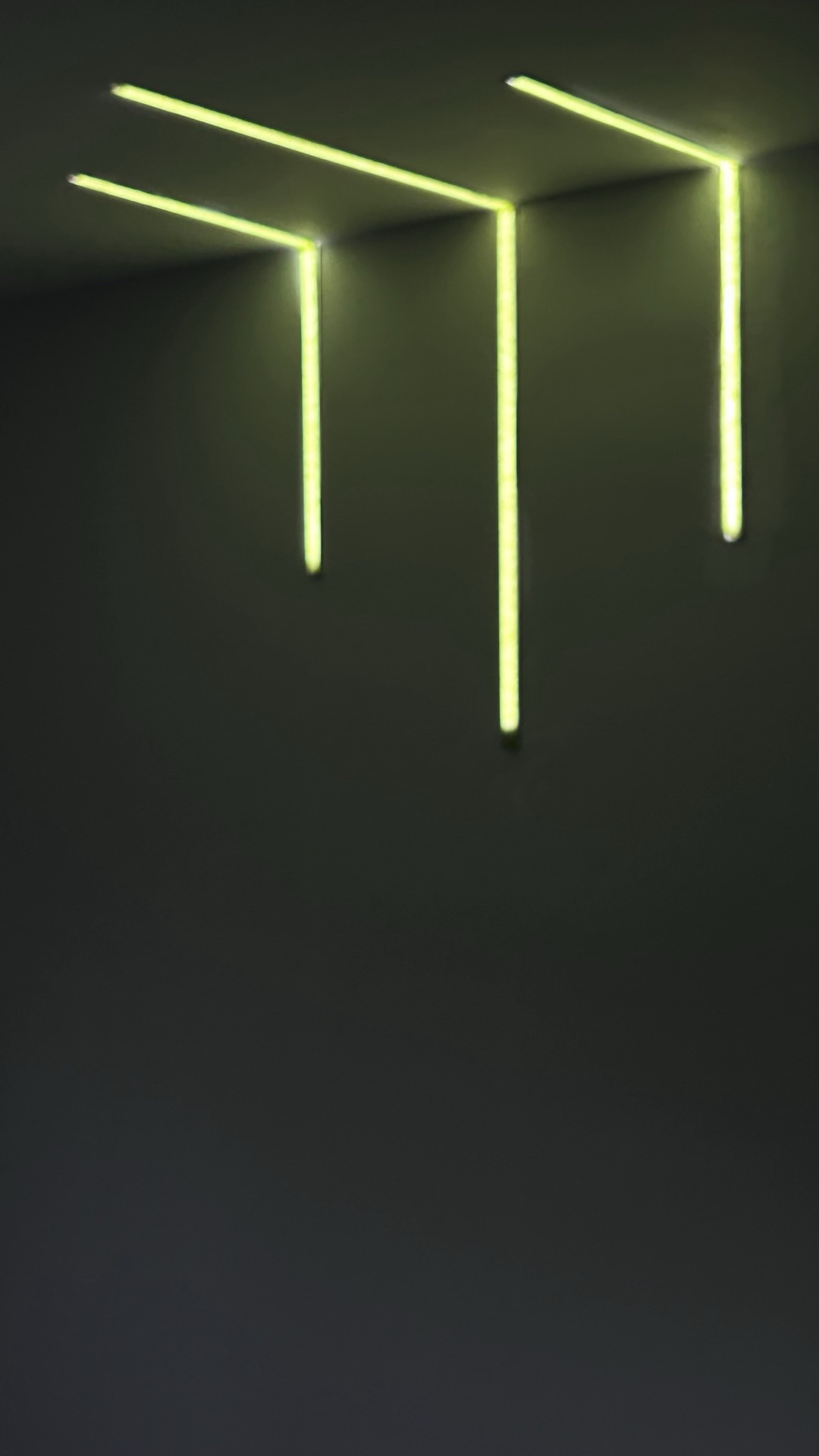 Linear LED ceiling installation by GP Electric, glowing green light bars on a dark ceiling